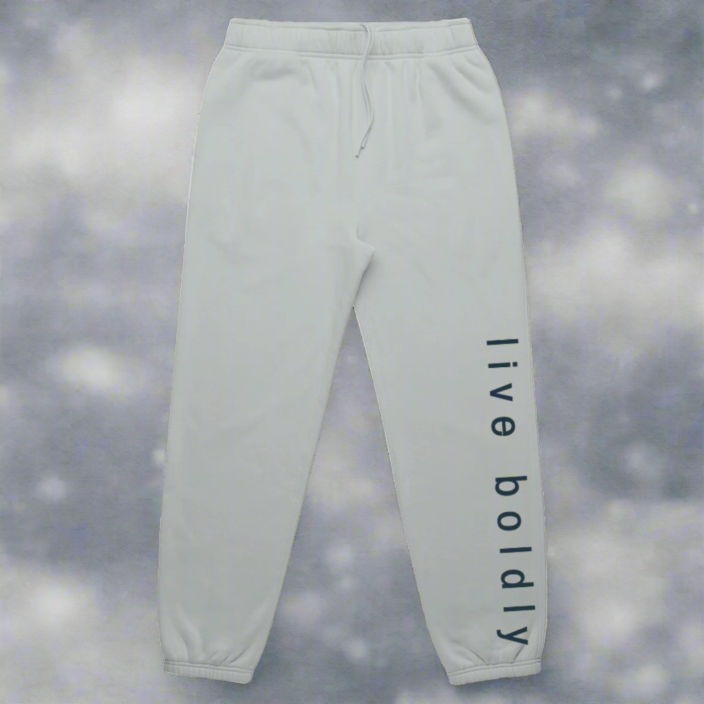 MOVE. MAKE. BLOOM. Bold & Free Relax Track Pants from the Bold & Free Winter Collection in smoke showing the phrase "live boldly" on the left side of the leg